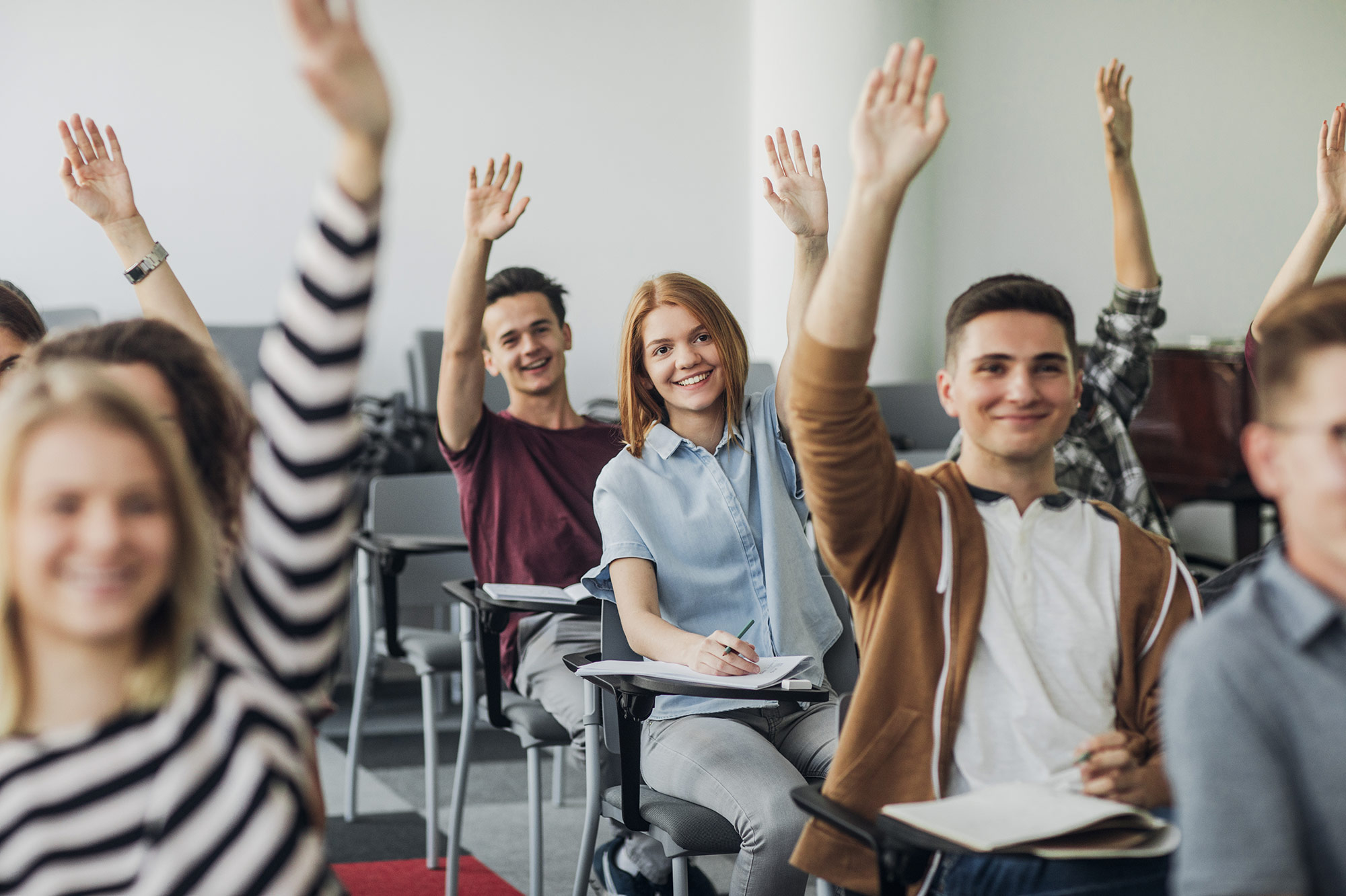 Students raising their hands in a classroom